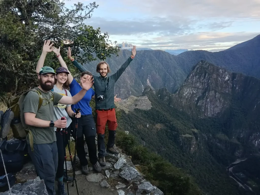 Machu Picchu tours hikers arriving at the Sun Gate with citadel view in the distance
