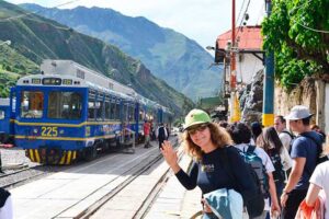 Families and travelers boarding a train at Ollantaytambo station heading to Machu Picchu