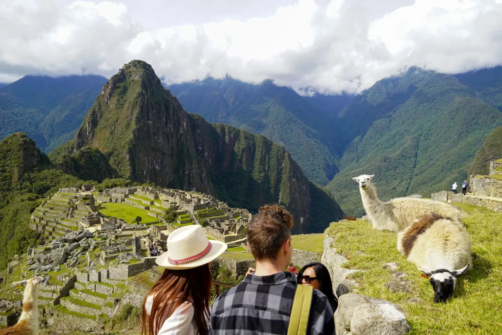 Traveler standing at a classic viewpoint with llamas in the foreground