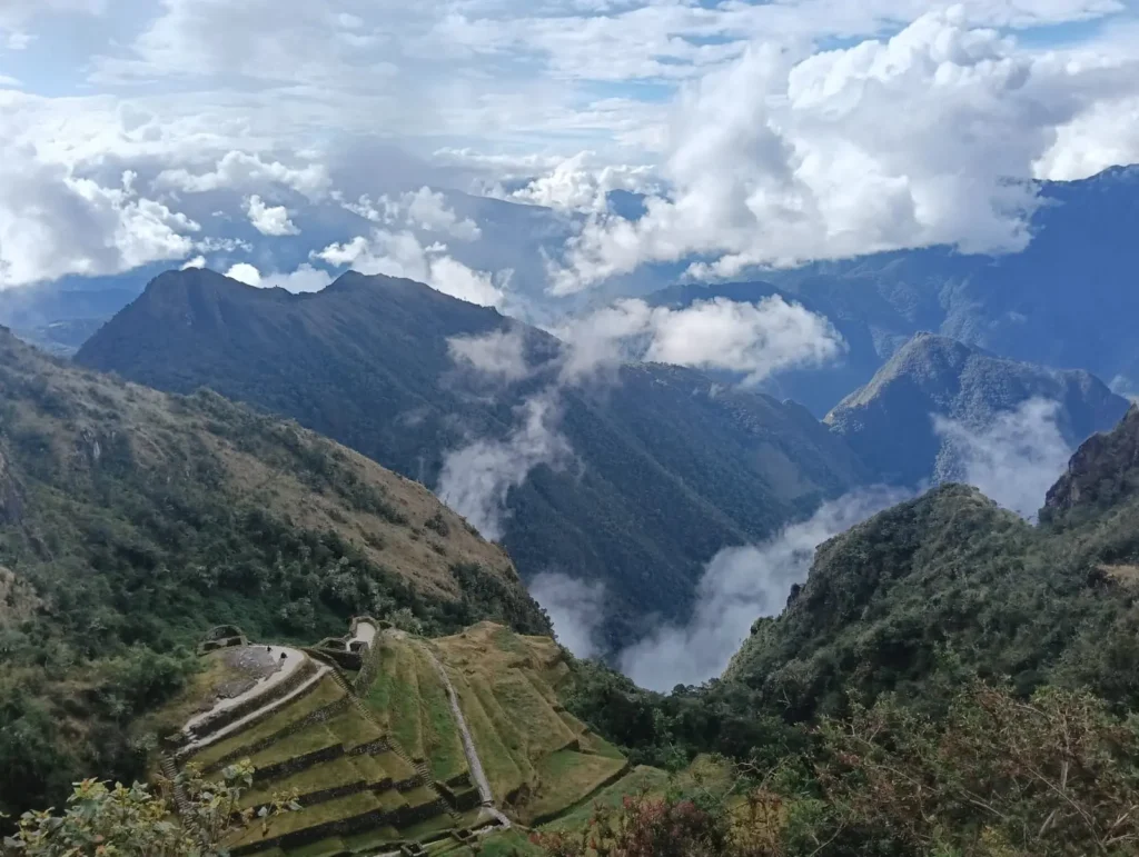 ALT: Ancient Inca ruins on a misty hillside surrounded by cloud forest on day three of the trek